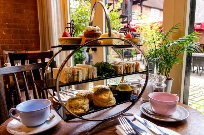 A tiered stand with sandwiches, scones, and pastries for afternoon tea