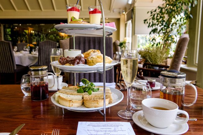 A tiered stand with various pastries and drinks at a dining table