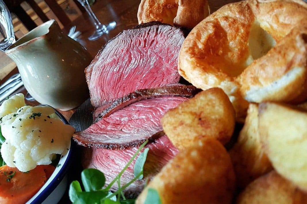 A plate of roast beef with Yorkshire pudding and vegetables