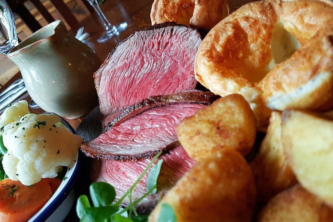 A plate of roast beef with vegetables and Yorkshire pudding