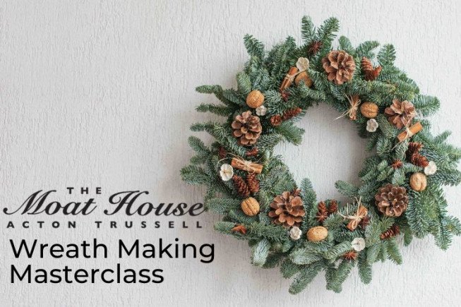 A festive wreath adorned with pinecones and nuts on a wall.